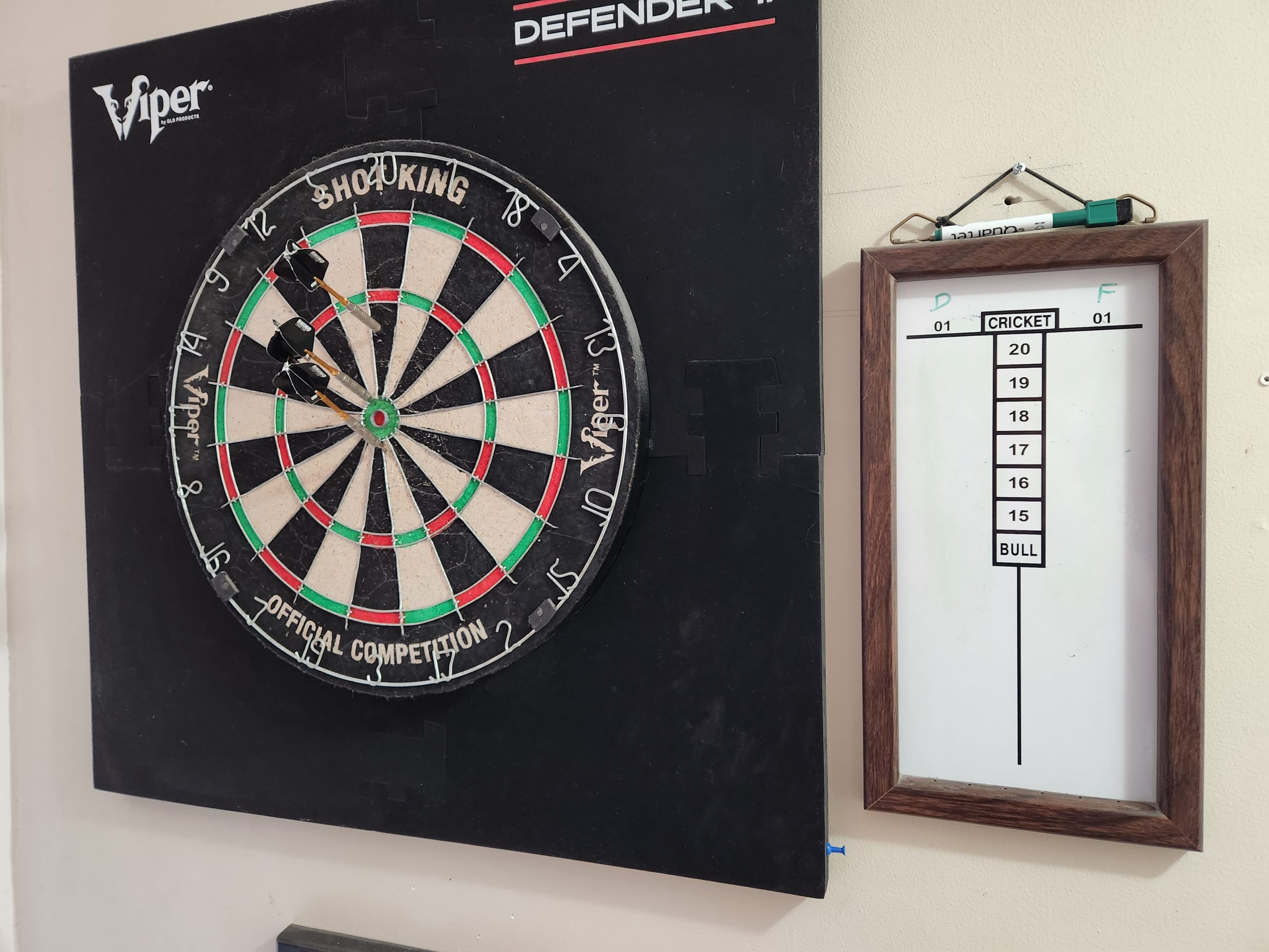 Dartboard with darts and cricket score board